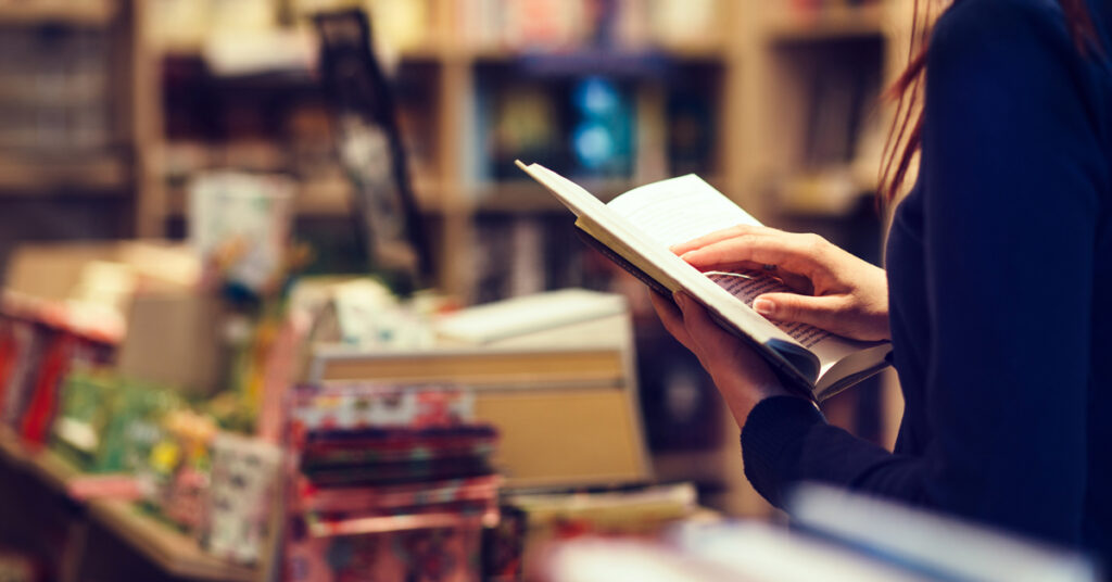 Close-up image of a customer looking at a book in a church bookstore.