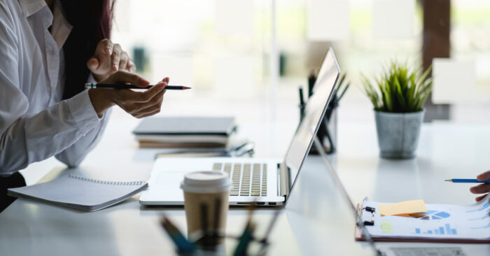 Financial leaders reviewing documents and data at a desk.