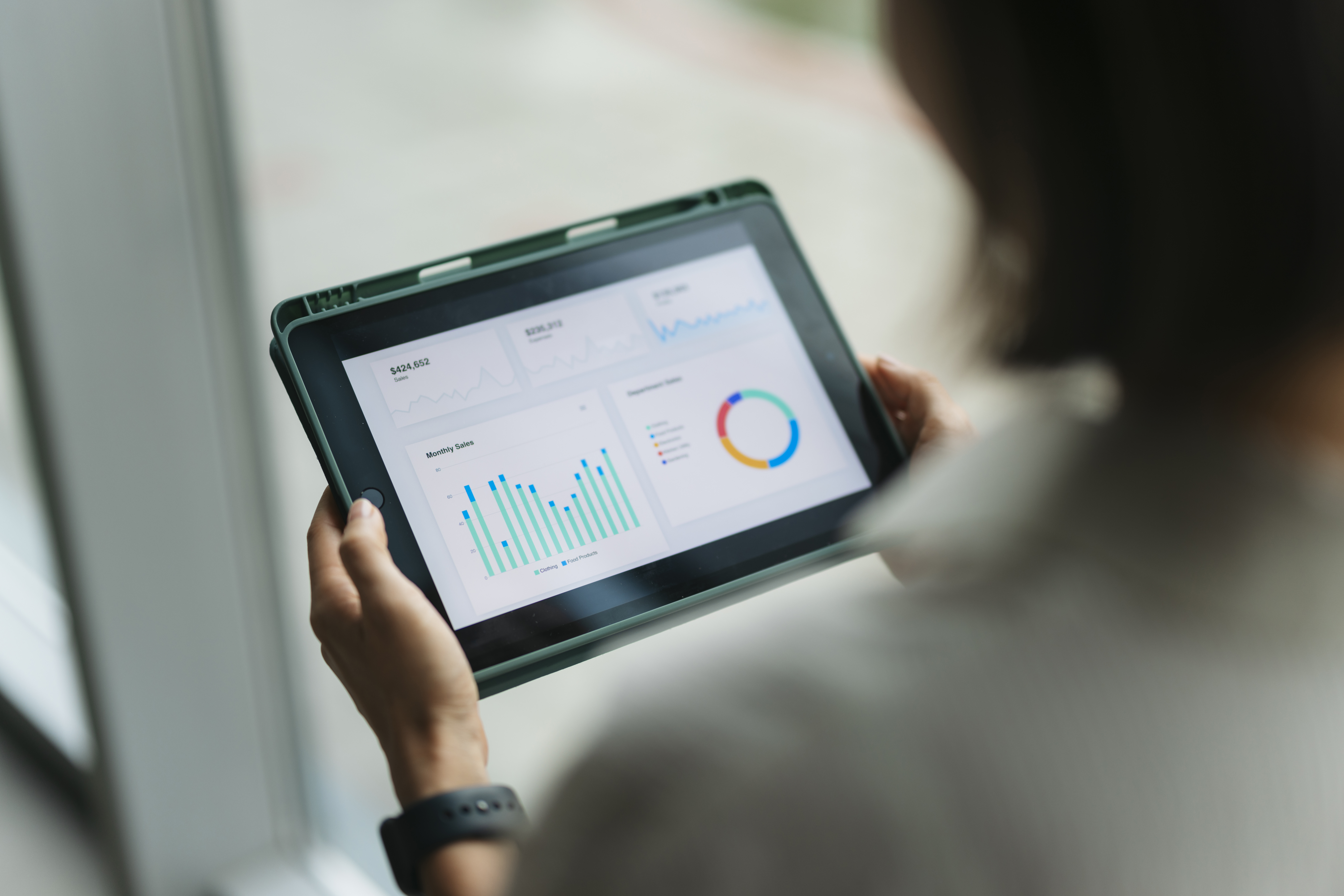Organizational leader reviewing graphs and charts of nonprofit outcome metrics on a digital tablet.
