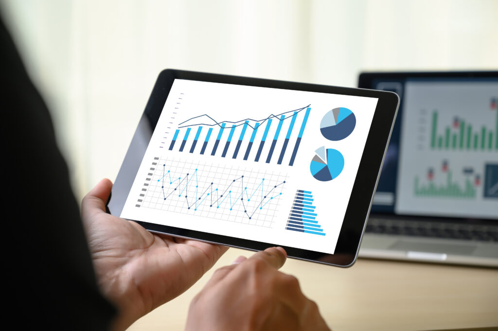 Hand holding a tablet with charts and graphs on the screen, representing accounting tech stack optimization.