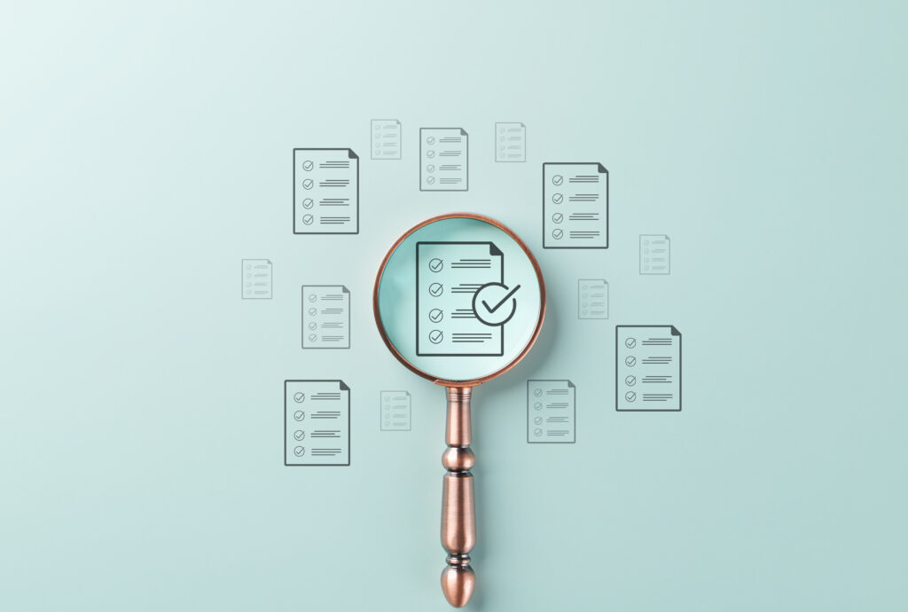 A magnifying glass over a checklist document, symbolizing nonprofit accounting software evaluation.