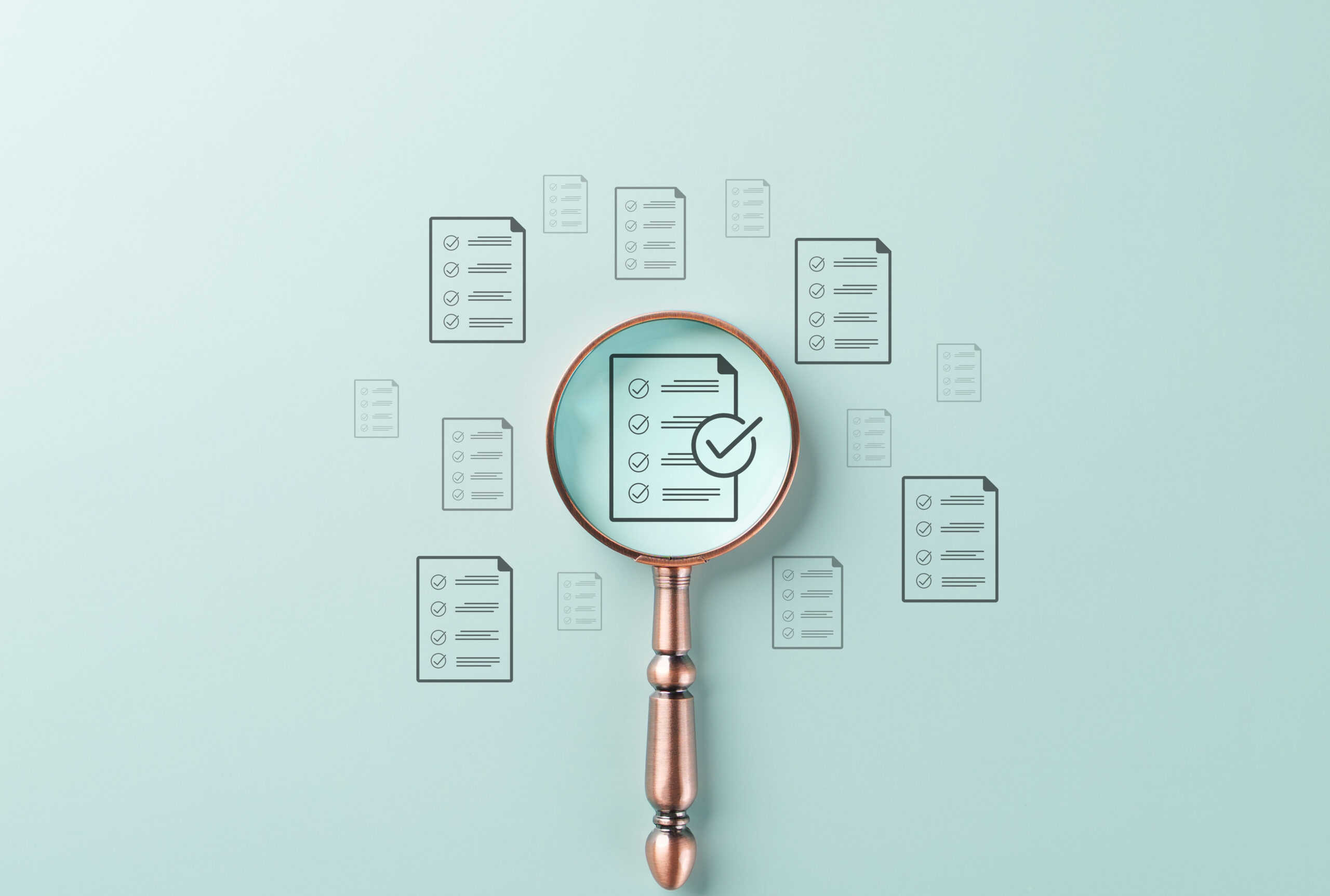 A magnifying glass over a checklist document, symbolizing nonprofit accounting software evaluation.