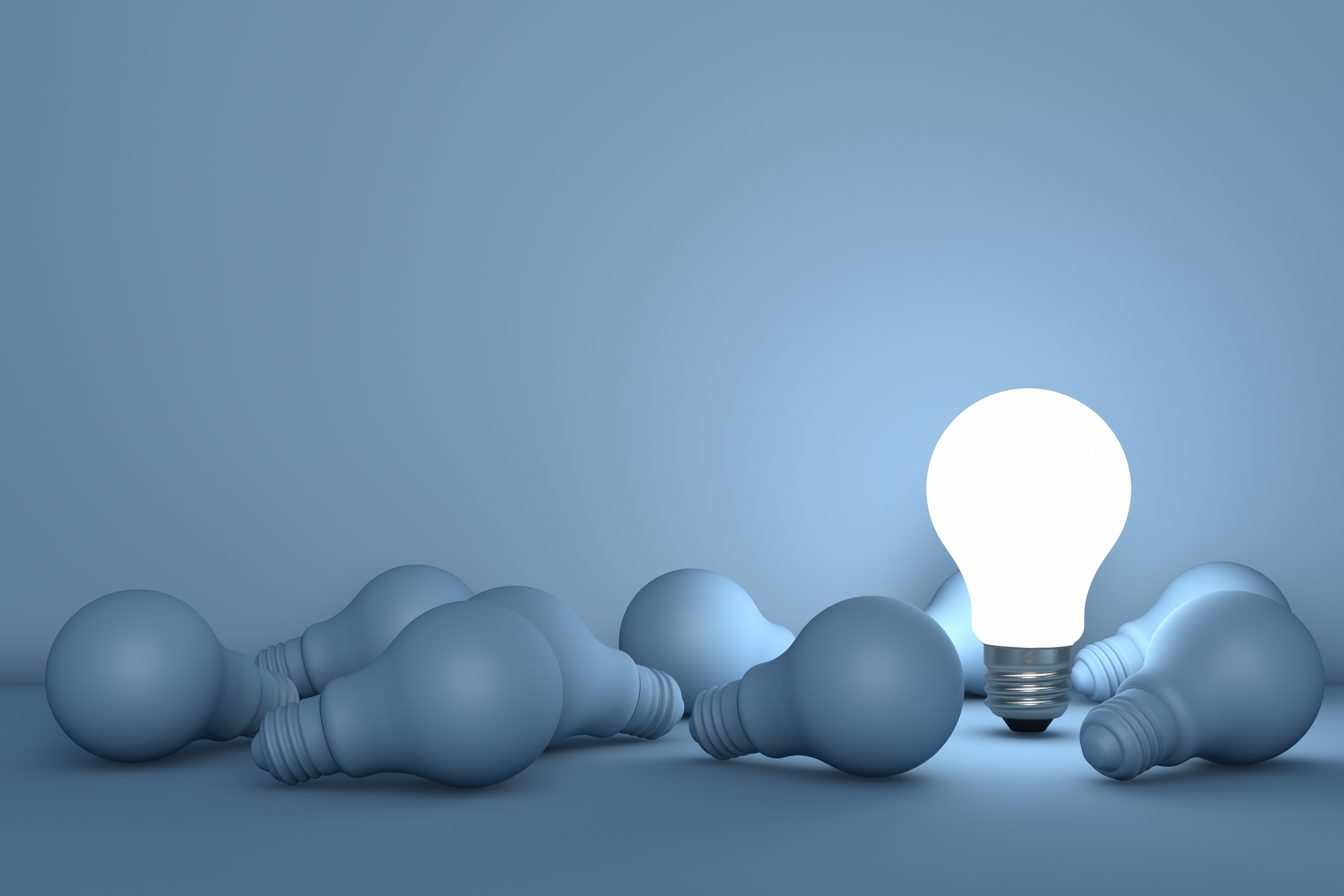 One lit, upright light bulb beside multiple unlit lightbulbs, representing the importance of choosing the right advisor for a nonprofit.