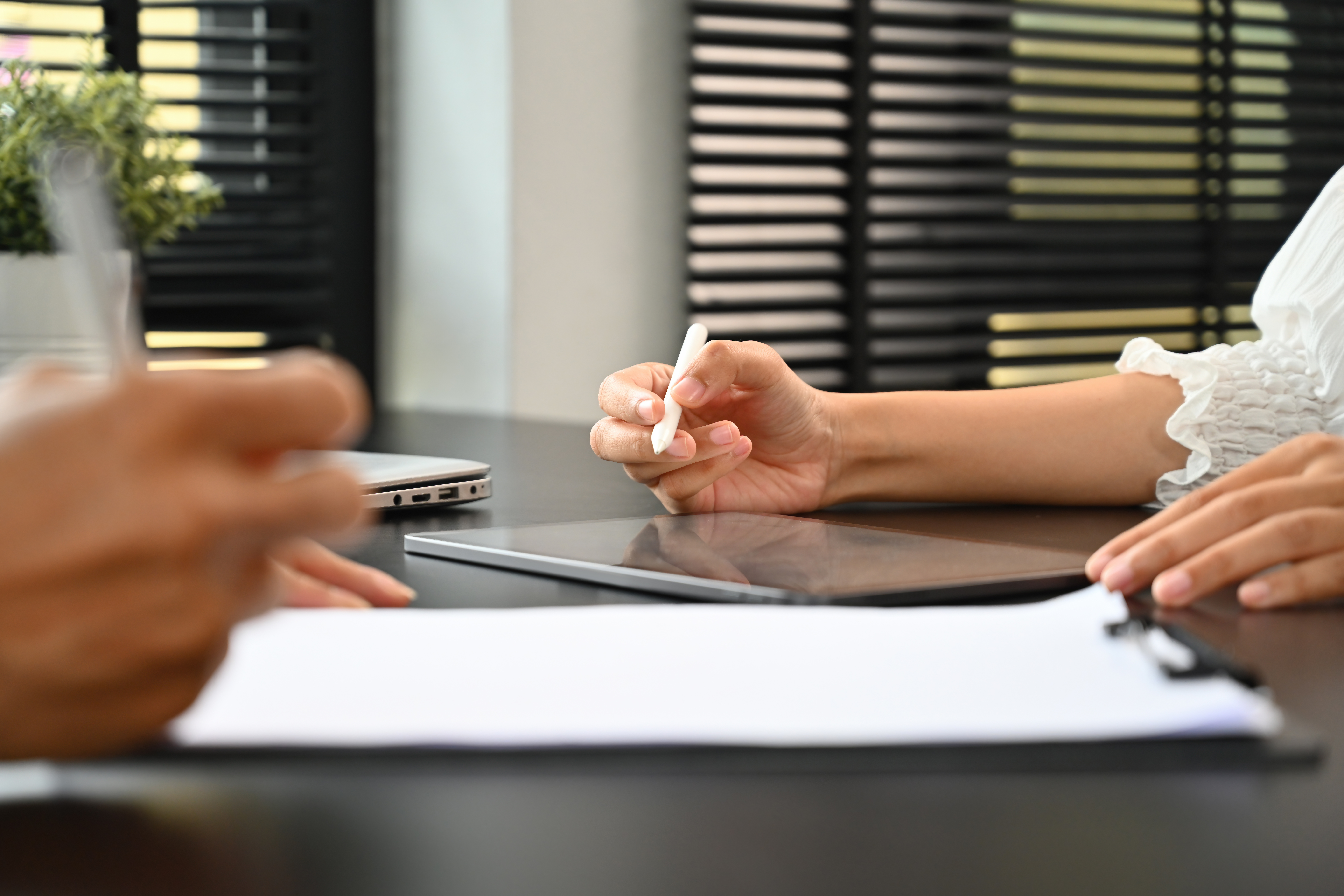 Close-up image of two nonprofit leaders working with a tablet and discussing a gift agreement document.