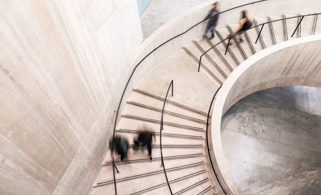 Blurred image of people descending a spiral staircase, representing the need for clear nonprofit financial leadership roles